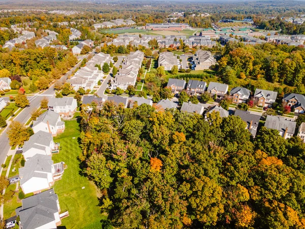 American suburb, view from above. Autumn landscape with colorful trees. Real estate, residential buildings of one-story America.