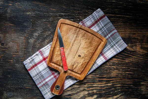 Deska Krojenia Ręczniku Ciemnym Drewnianym Stole Kuchennym Widok Góry — Zdjęcie stockowe