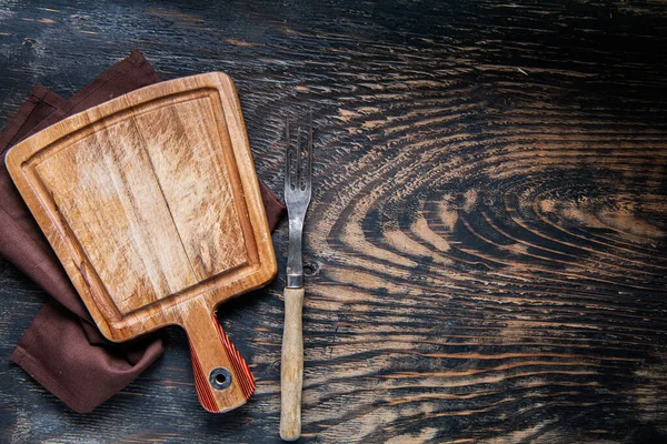 木刻板 叉子和餐巾 桌子的深色背景 顶视图 版权空间 — 图库照片