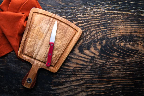 Prázdná Dřevěná Řezací Deska Nůž Ubrousek Stůl Tmavé Pozadí Pohled — Stock fotografie