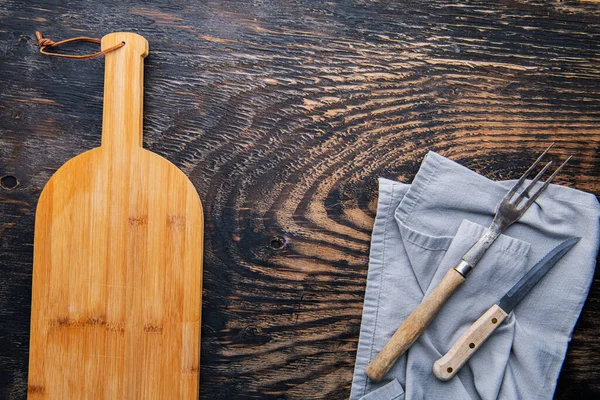 用刀和叉子在木制桌子上空的老式木刻板 从上面看 — 图库照片