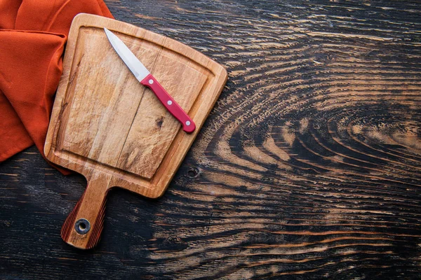 Stara Deska Krojenia Nożem Serwetką Ciemnym Drewnianym Stole Widok Góry — Zdjęcie stockowe