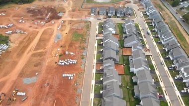 Yeni evleri ve yeni inşaatı olan bir inşaat alanı. Kırmızı kil ve iletişim. Ekipman ve borular. Yukarıdan görüntüle.