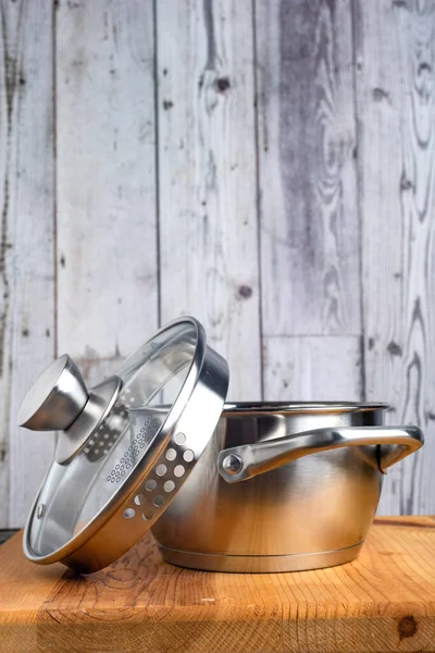 木製のテーブルの上にガラス蓋付きステンレス製の鍋 — ストック写真