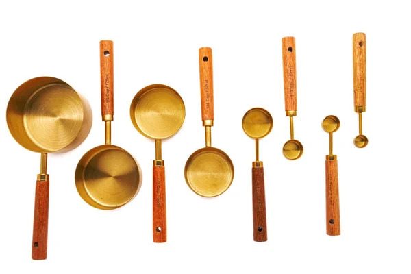 白色背景的木制手柄铜测量勺子 — 图库照片