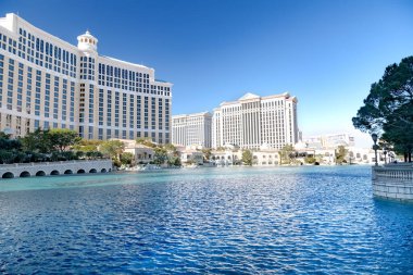 Las Vegas 'taki Belagio Oteli' nin yanındaki Fantan göleti. Güneşli bir günde mavi suların yakınında restoranlar ve butiklerle gezinti..