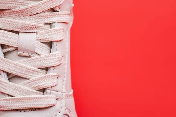拉紧新运动鞋的特写 现代纺织培训师的弹性鞋带 以适应积极的生活方式 运动和红色背景的健康 复制空间 — 图库照片