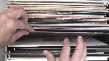 Erkek müzik aşığı bir müzik dükkanında plak yığınını karıştırıyor. Yakın plan..