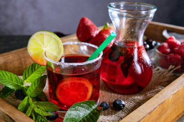 Taze böğürtlen, çilek, kiraz ve ahududu, buzlu limonata ve cam.