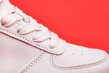 Yeni spor ayakkabılarının bağcıkları birbirine çok yakın. Kırmızı arka planda aktif yaşam tarzı, spor ve fitness için modern tekstil eğitmenlerinin elastik bağcıkları. Boşluğu kopyala.