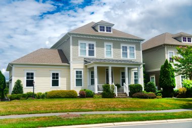 Yol kenarında verandası ve çimenliği olan tek kişilik bir Amerikan evi..