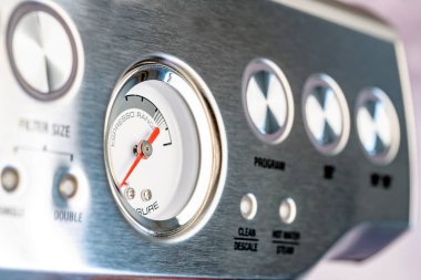 Kontrol düğmeleri ve barometresi olan modern çelik kahve makinesi. Yakın plan. Seçici odak.