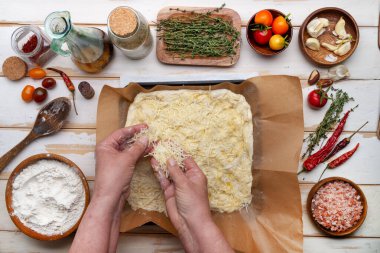 Çeri domatesli ve kırmızı biberli ev yapımı İtalyan düz ekmekleri ahşap masa üzerinde pişirmek. Yukarıdan görüntüle.