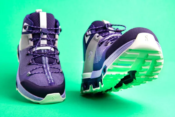 Yeşil Arka Planda Yürüyen Bir Çift Spor Ayakkabısı Sıradan Şık — Stok fotoğraf
