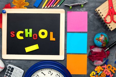 Okul gereçleri, renkli mektuplar, bir dünya ve üzerinde 