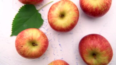 Kesme tahtasındaki elmalar, bıçakla ve beyaz bir masada bir sürü elmayla. Yukarıdan görüntüle.