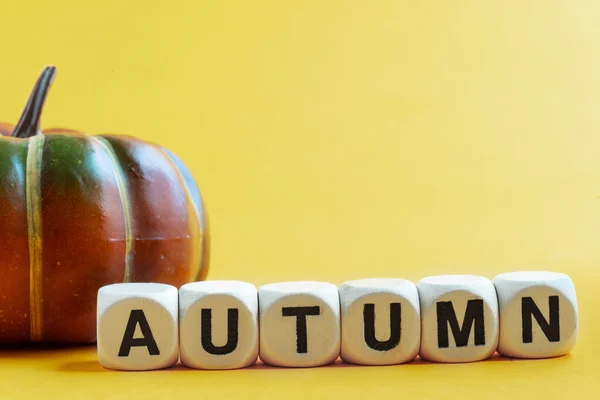 Dekoracyjna Dynia Żółtym Tle Napis Autumn Złożone Drewnianych Kostek Miejsce — Zdjęcie stockowe