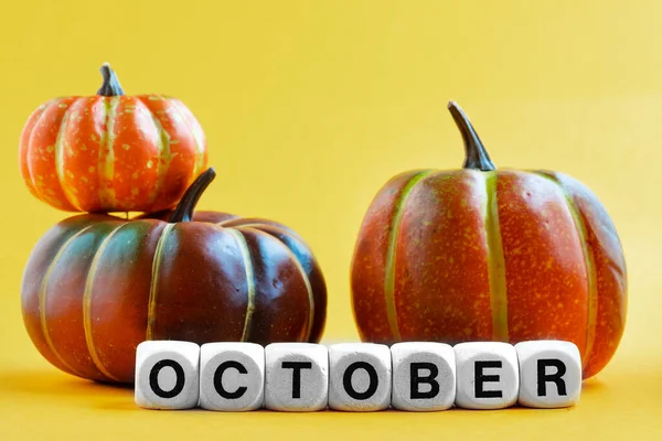 Miniatyr Pumpor Och Ordet Oktober Monteras Från Träblock Gul Bakgrund — Stockfoto