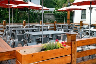 Eski bir Amerikan kasabasında, bir yaz gününde boş bir sokak kafesi. Masalar, sandalyeler ve şemsiyeler.