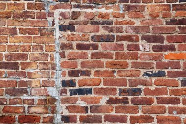 Arka planda yamalar olan eski kırmızı tuğla duvar
