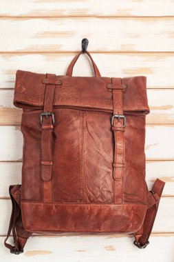 Duvarda asılı kahverengi deri sırt çantası