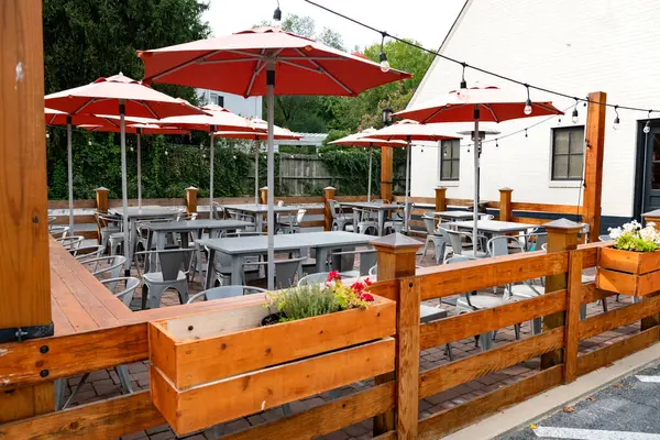 Eski bir Amerikan kasabasında, bir yaz gününde boş bir sokak kafesi. Masalar, sandalyeler ve şemsiyeler.