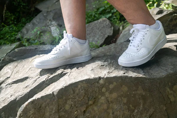 Beyaz Nike Spor Ayakkabıları Bir Dağcının Ayağında Kayalara Tırmanıyor — Stok fotoğraf