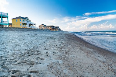 Atlantik Okyanusu kıyısındaki mavi gökyüzünün altında kumsal ve evler