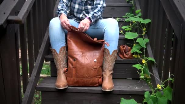 Kobieta Pakuje Brązowe Akcesoria Skórzane Plecaka Siedząc Schodach Zbliżenie Rąk — Wideo stockowe