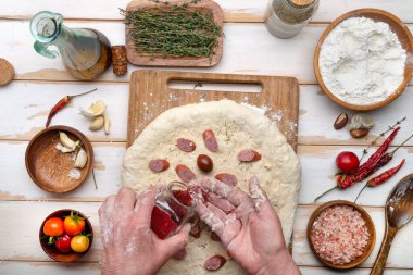 Kadın fırıncı, pasta şefi ya da aşçı hamuru doldurur. Pizza pişiriyorum. Yukarıdan görüntüle.