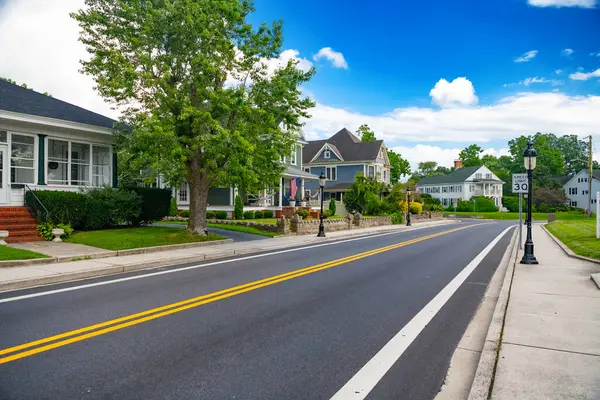 stock image asphalt road with Yellow dividing strips in a small American city. Blue cloudy sky.