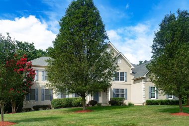 Geleneksel Amerikan tarzı tek aile kır evi. Büyük çimler ve ağaçlar.