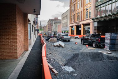 Yol çalışmaları sırasında inşaat malzemeleri yüksek binalar arasında kentsel bir çevrede çalışır..