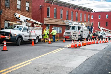 Yol kapanıyor. Verizon işçileri rögar kapağına kablo indiriyor. İnternet hata ayıklaması için Verizon özel ekipmanı