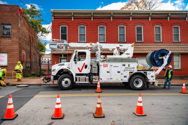 Verizon işçileri rögar kapağına kablo indiriyor (dijital kompozit). İnternet hata ayıklaması için Verizon özel ekipmanı