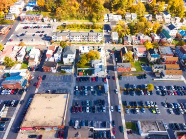 Yukarıdan otopark manzarası. Sonbaharda Maryland 'de eski bir kasaba. Evler, otoparklar, arabalar, sarı ağaçlar ve tepeler arasında.