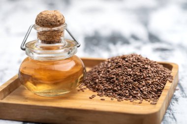 Keten tohumu yağı ve kahverengi keten tohumu yakın plan bir tepside..