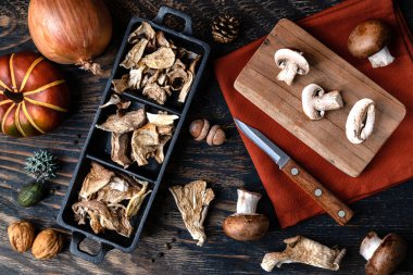 Tahta bir masada çeşitli kurutulmuş mantarlar. Yukarıdan görüntüle.