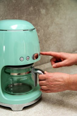 Düğmeleri olan modern bir kahve makinesinin yakın çekimi. Seçili bir düğmeye basarak çelikte geriye dönük tasarım.