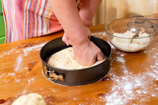 Chef places the dough into a baking pan or cheesecake pan.