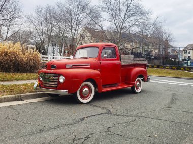 Caddeye park edilmiş kırmızı Ford F100 kamyonet 1955 ön köşe görüntüsü