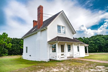 Geleneksel Amerikan tarzında eski bir ev. Verandalı güzel beyaz bir bina. Yaz günü, mavi gökyüzü.