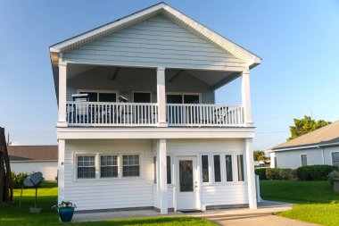 Atlantik Okyanusu 'nun kıyısındaki iki katlı kulübe. Palmiye ağaçları ve mavi gökyüzü.