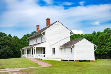 Geleneksel Amerikan tarzında eski bir ev. Verandalı güzel beyaz bir bina. Yaz günü, mavi gökyüzü.