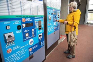 woman refills her electronic card at a machine for travel at a metro station. Washington Metro. clipart