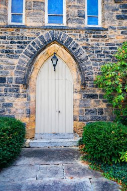 Ön cephe tasarımı. Taş bir duvarın içindeki ahşap ön kapının yakın görüntüsü..