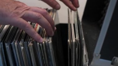 Erkek müzik aşığı bir müzik dükkanında plak yığınını karıştırıyor. Yakın plan..