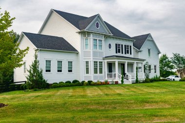 İki katlı, yeşil çimenli müstakil bir ev.