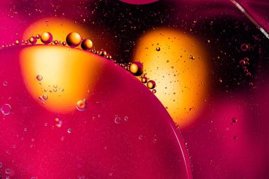 Renkli yağ damlaları kabarcıklar ve küreler. Su yüzeyinde akıyor. Soyut arkaplan Makro Fotoğrafçılık
