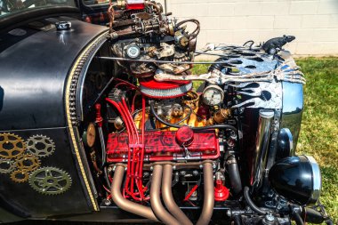 Kaputu açık siyah retro-araba, motor bölmesinin tepesini gösteriyor. Vücudunda kafatasları ve farları olan iskeletler.